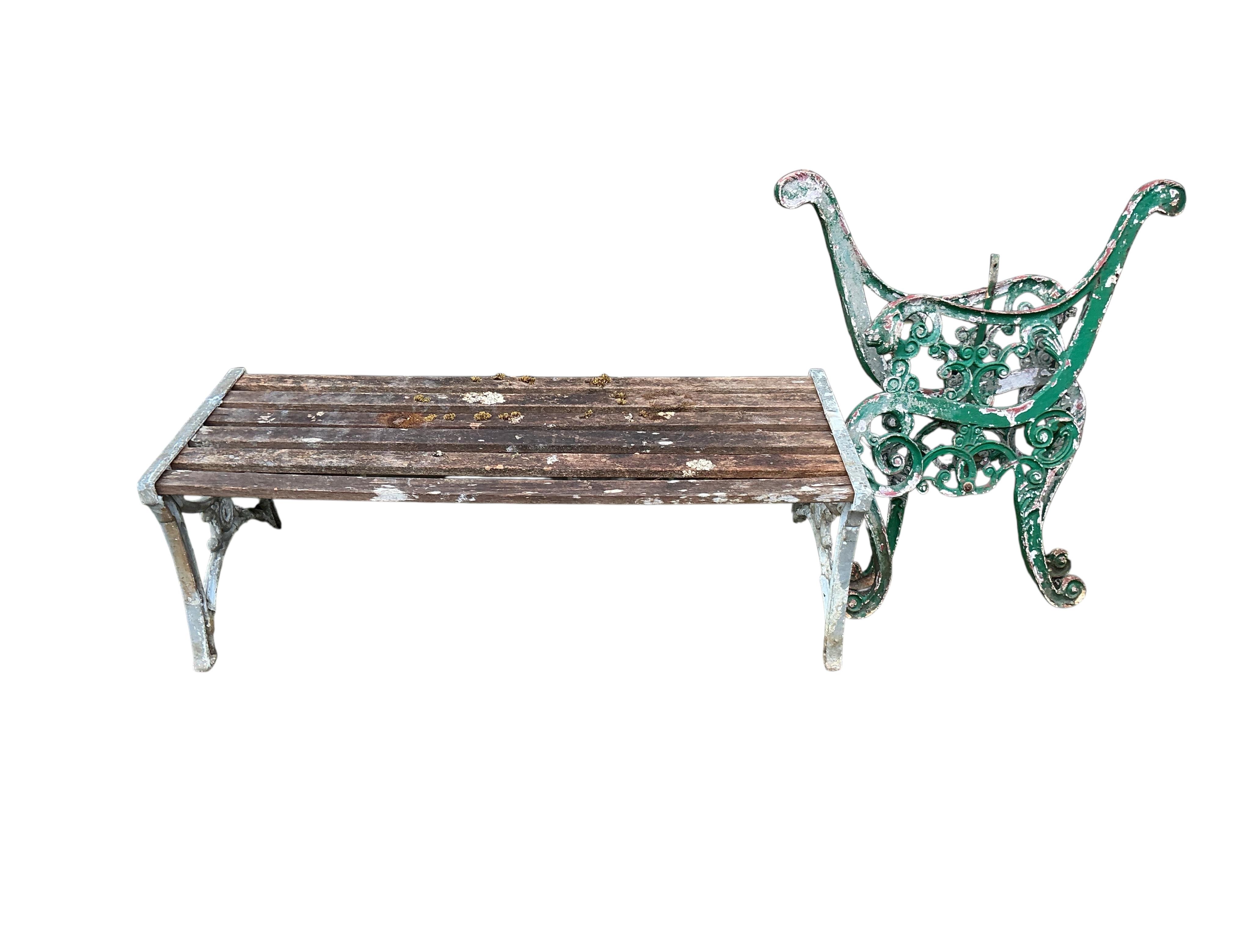 A pair of Victorian style cast metal bench ends and a slatted wood garden bench